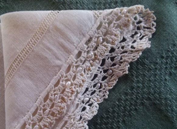 The photo shows a crocheted border on a cut lace linen handkerchief. The lace is 100/2 fine linen lacing making thread and incorporates size 16 hex cut glass beads, very small freshwater pearls and antique size 22 gold plated seed beads into the lace pattern.