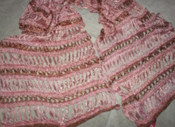 Photo shows a broomstick lace crochet wrap made of alternating of Artyarns lace weight silk essence yarn in Ombre Rose pink with tan highlights and burnt orange which is a very soft bright brown.
